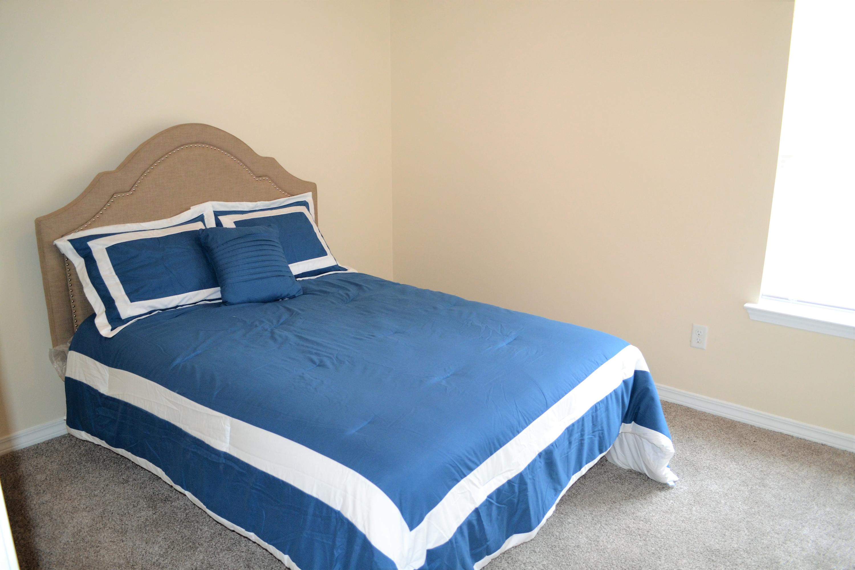 5237 Kervin Road Crestview, FL 32539 - Photo 16 of 28 a bed sitting in a bedroom next to a window and a lamp