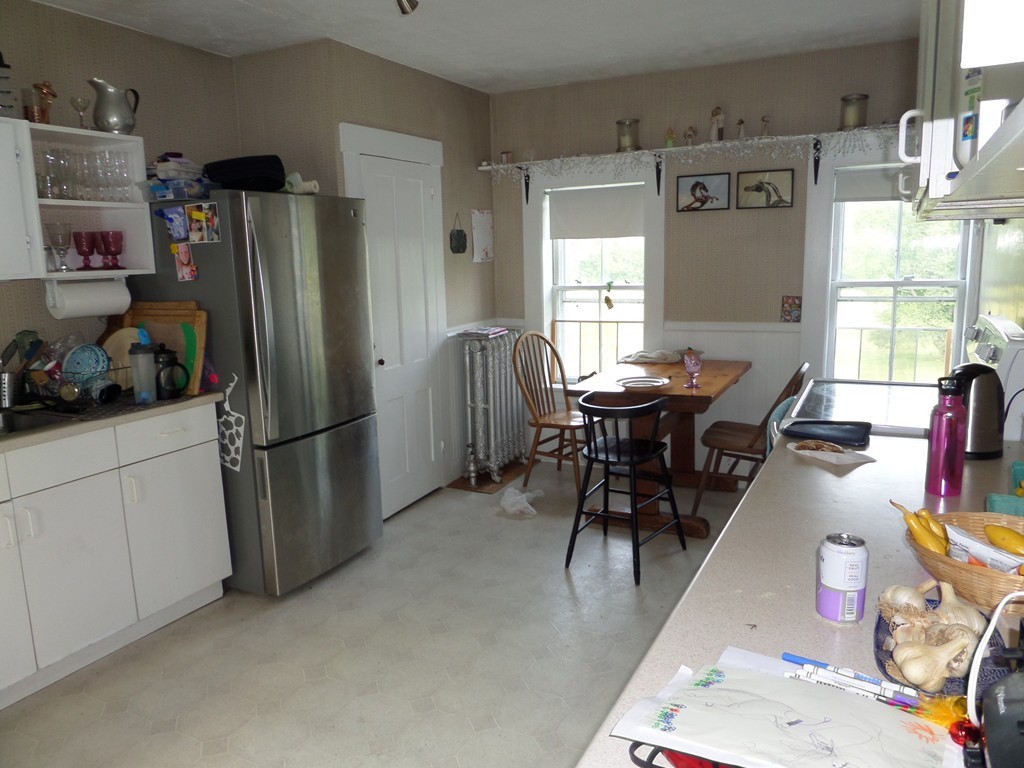 15 Bromley Road Huntington, MA 01050 - Photo 23 of 29 a kitchen with stainless steel appliances granite countertop dining table chairs and a refrigerator