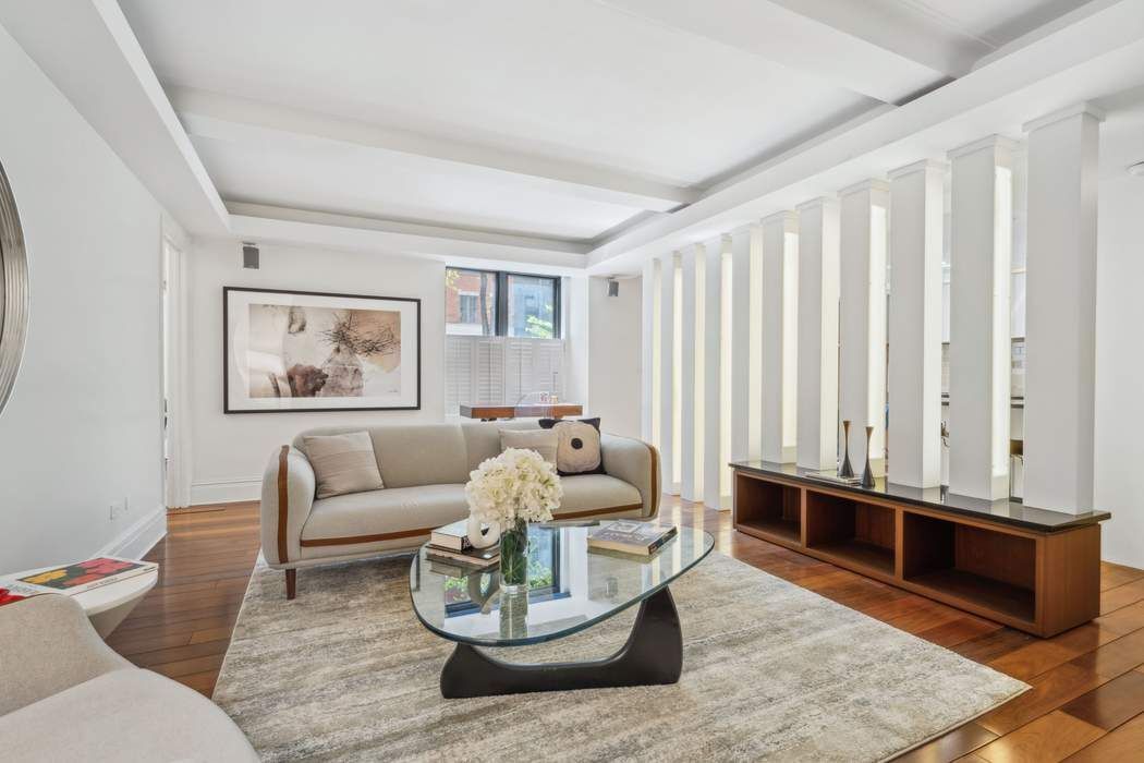 333 East 53rd Street, Unit 1J Manhattan, NY 10022 - Photo 2 of 15 a living room with furniture and wooden floor