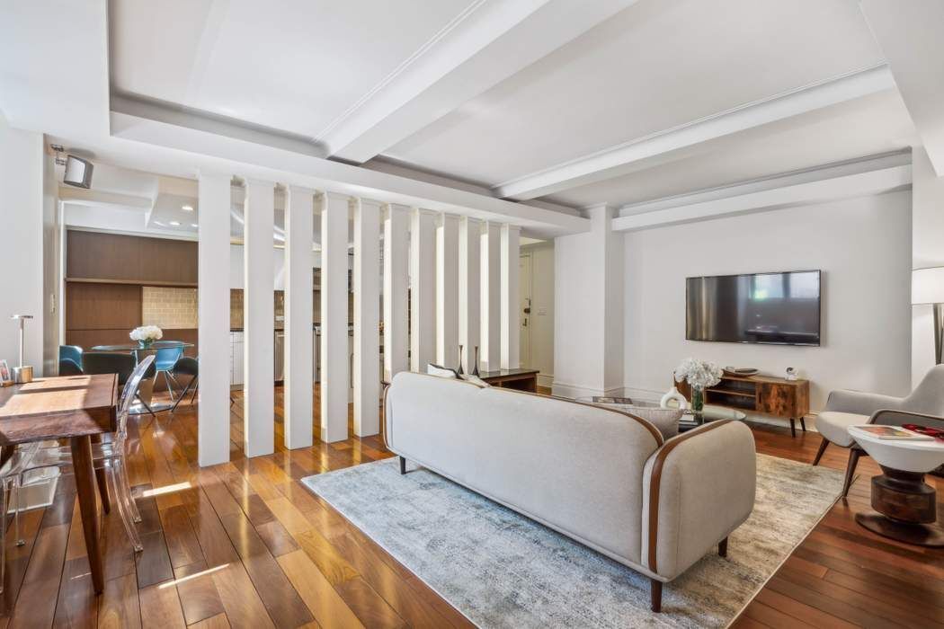 333 East 53rd Street, Unit 1J Manhattan, NY 10022 - Photo 8 of 15 a living room with furniture and a flat screen tv