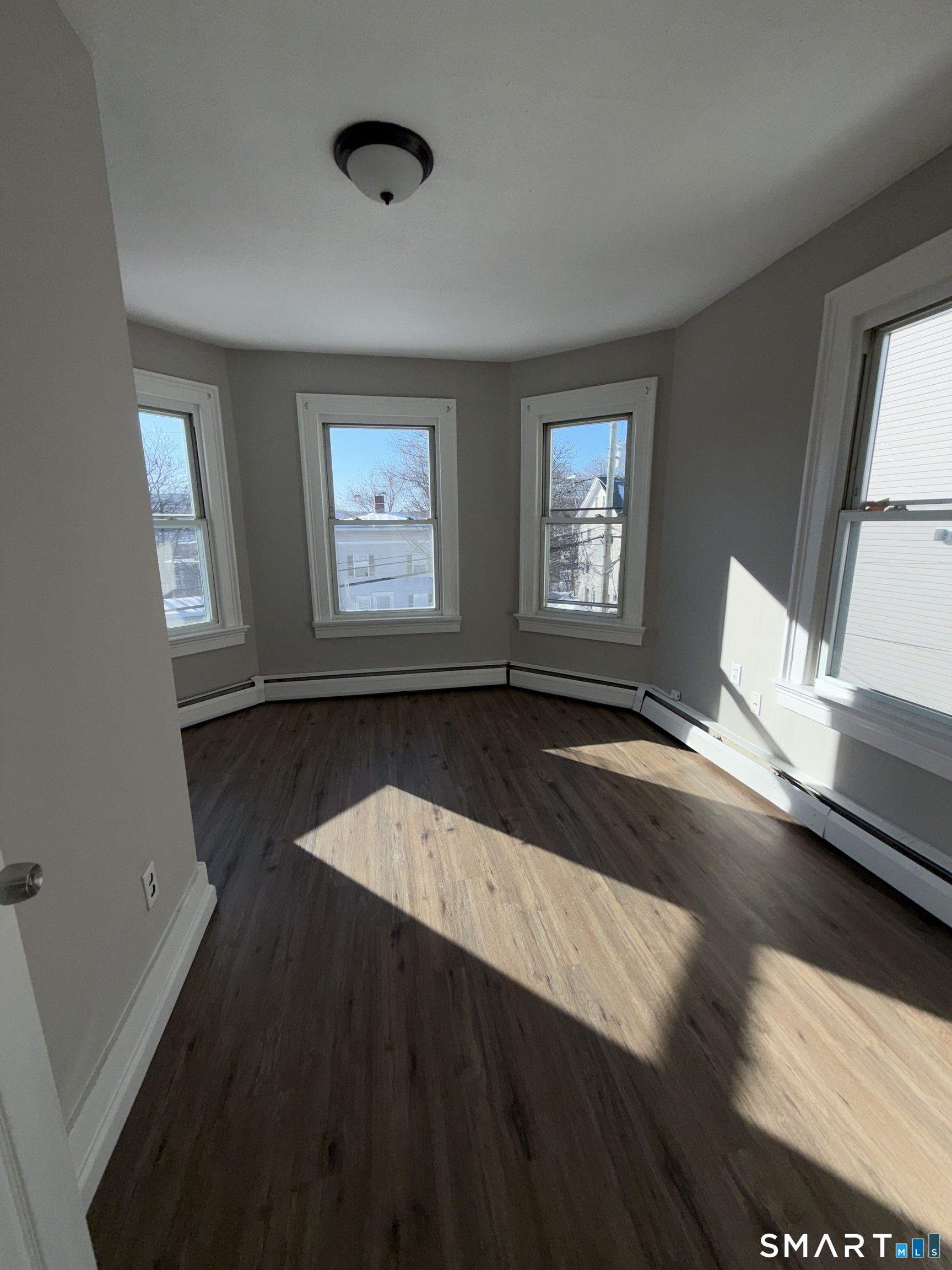 42 Summer Street, Unit 5 Bristol, CT 06010 - Photo 6 of 8 a view of an empty room with wooden floor and a window