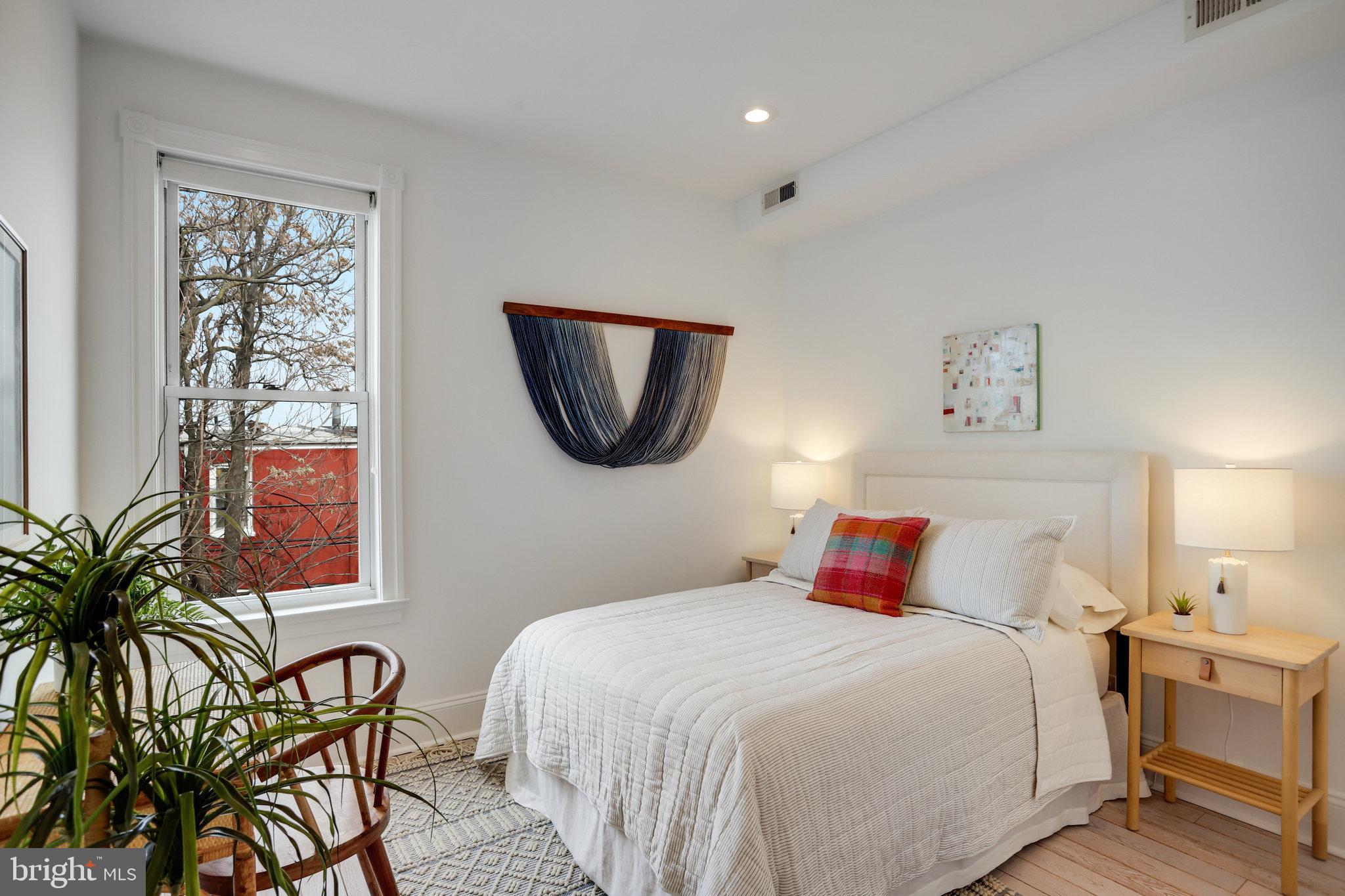 1322 E Street Northeast Washington, DC 20002 - Photo 37 of 49 a bedroom with a bed and a lamp on dresser