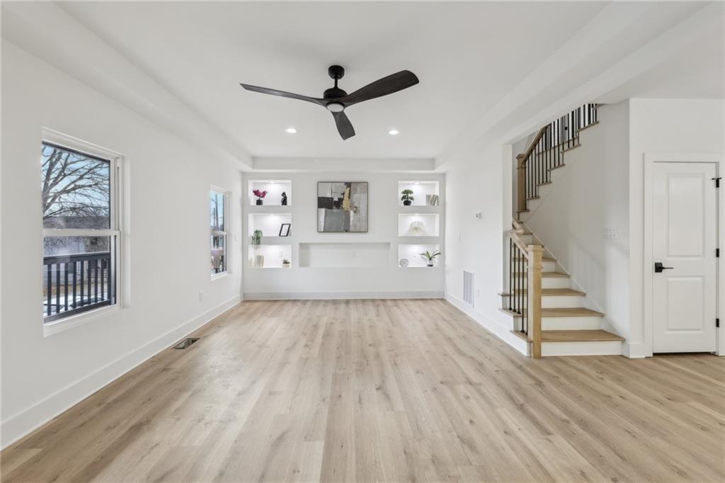 727 Garibaldi Street Southwest Atlanta, GA 30310 - Photo 8 of 84 a view of an empty room with wooden floor and a ceiling fan