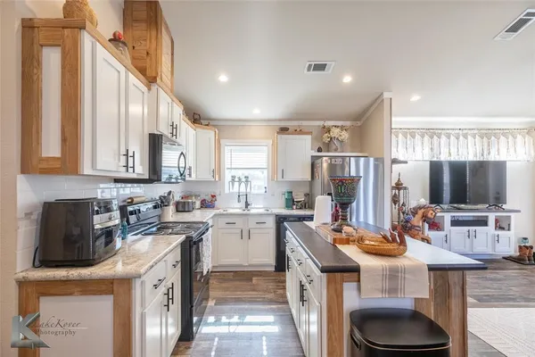 a kitchen with a sink a stove and chairs