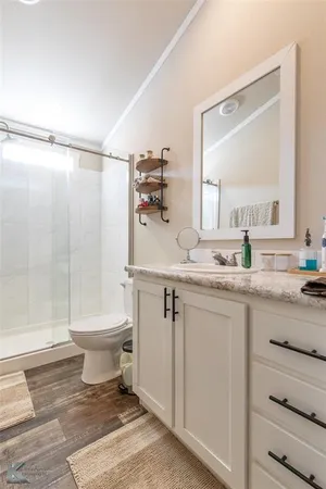 a bathroom with a granite countertop sink toilet and shower