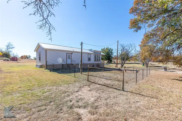 a view of a yard with wooden fence