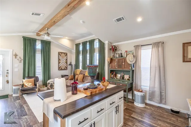 a view of a kitchen counter top space with wooden floor and furniture