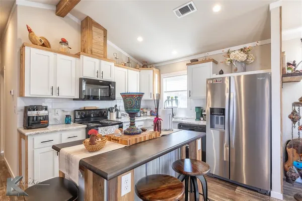 a kitchen with stainless steel appliances cabinets a sink and a refrigerator