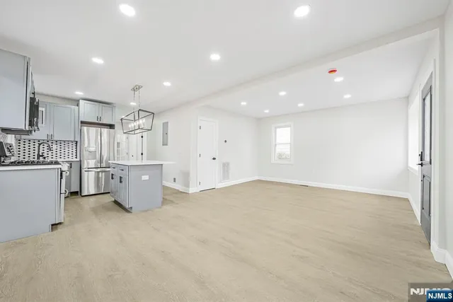a view of an empty room with a kitchen