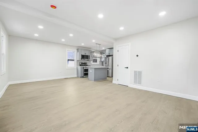 a view of empty room with a kitchen