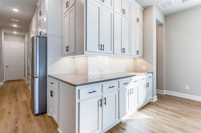 an entryway with wooden floor and cabinet