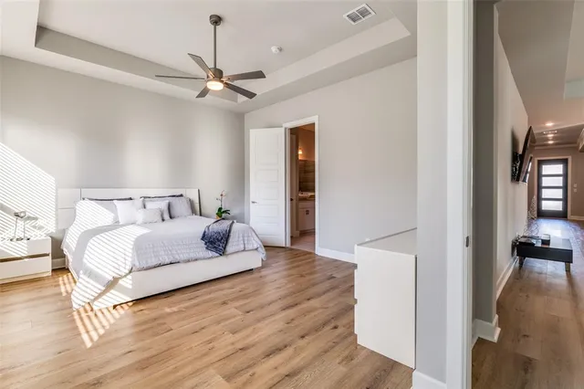 a bedroom with a bed chandelier and a view of bathroom