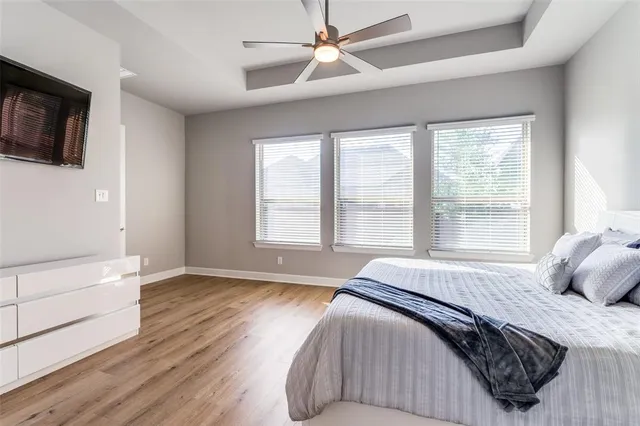 a bedroom with a bed a flat screen tv and a large window