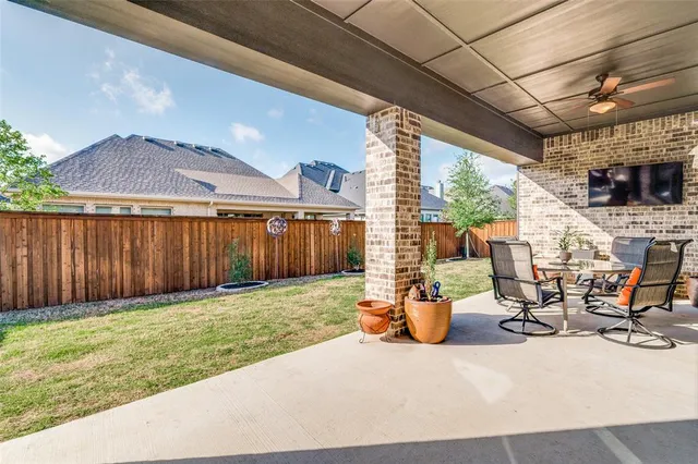 a view of a patio with table and chairs potted plants with wooden fence