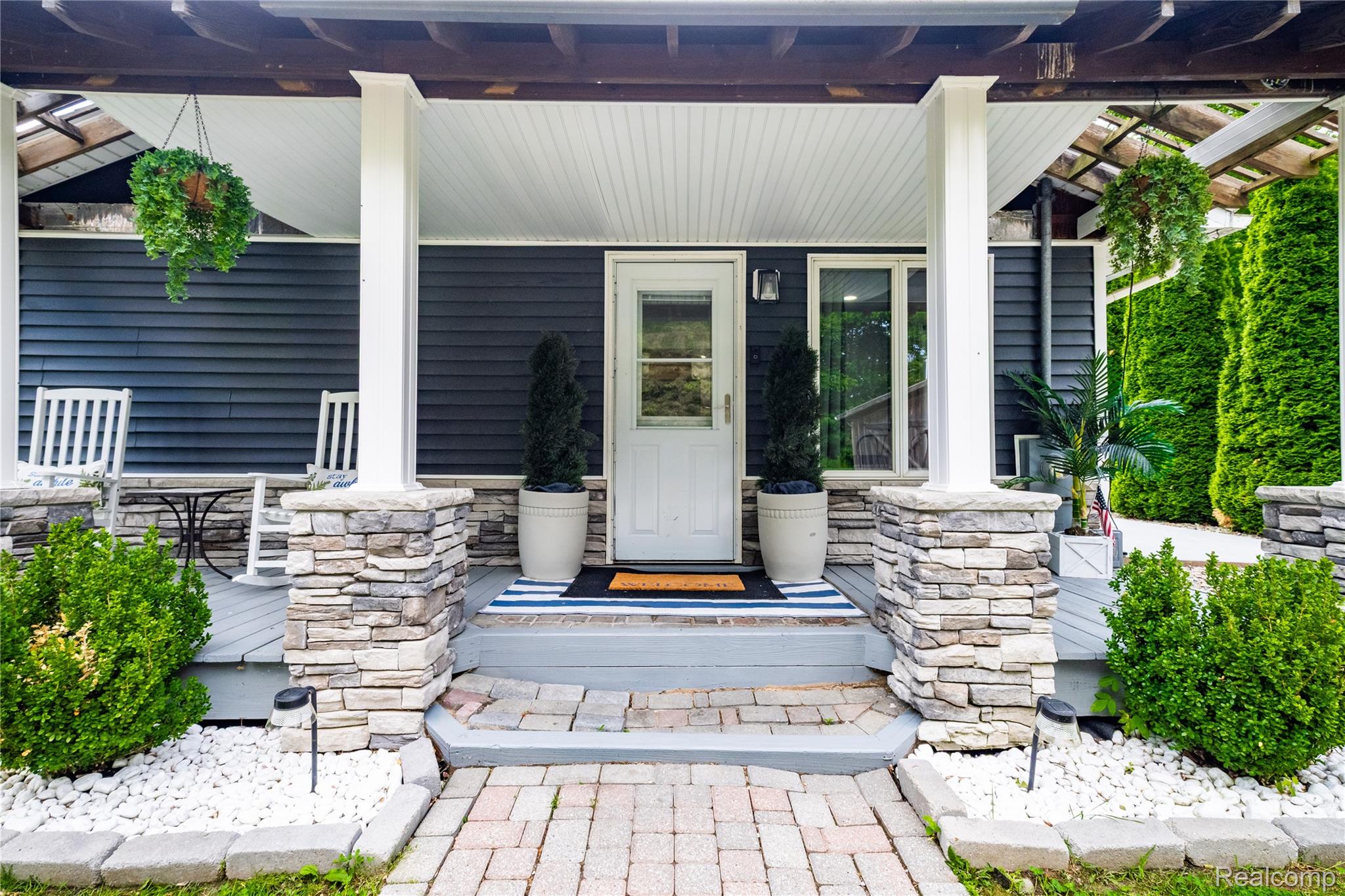 4418 North Gale Road Davison, MI 48423 - Photo 13 of 46 Inviting front porch featuring a white entry door, dark siding, stone-clad pillars, and a brick paver walkway