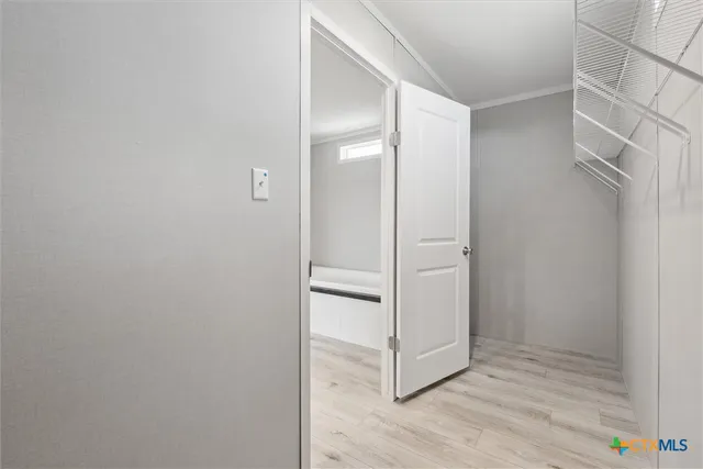 a view of walk in closet with empty racks
