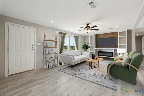 a living room with furniture a fireplace and a flat screen tv