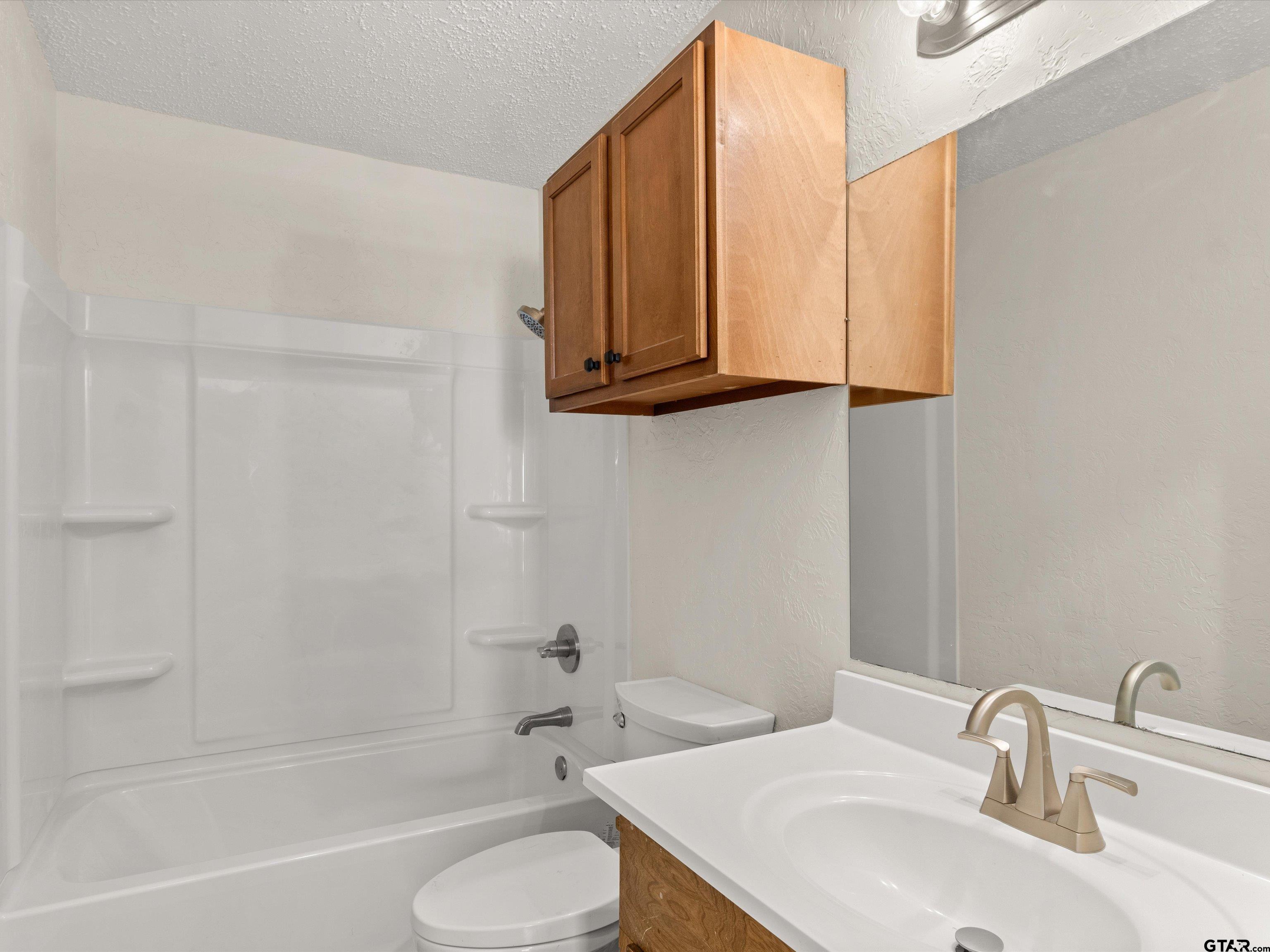 901 Skyview Drive Gilmer, TX 75644 - Photo 14 of 18 a bathroom with a sink a toilet and a bathtub
