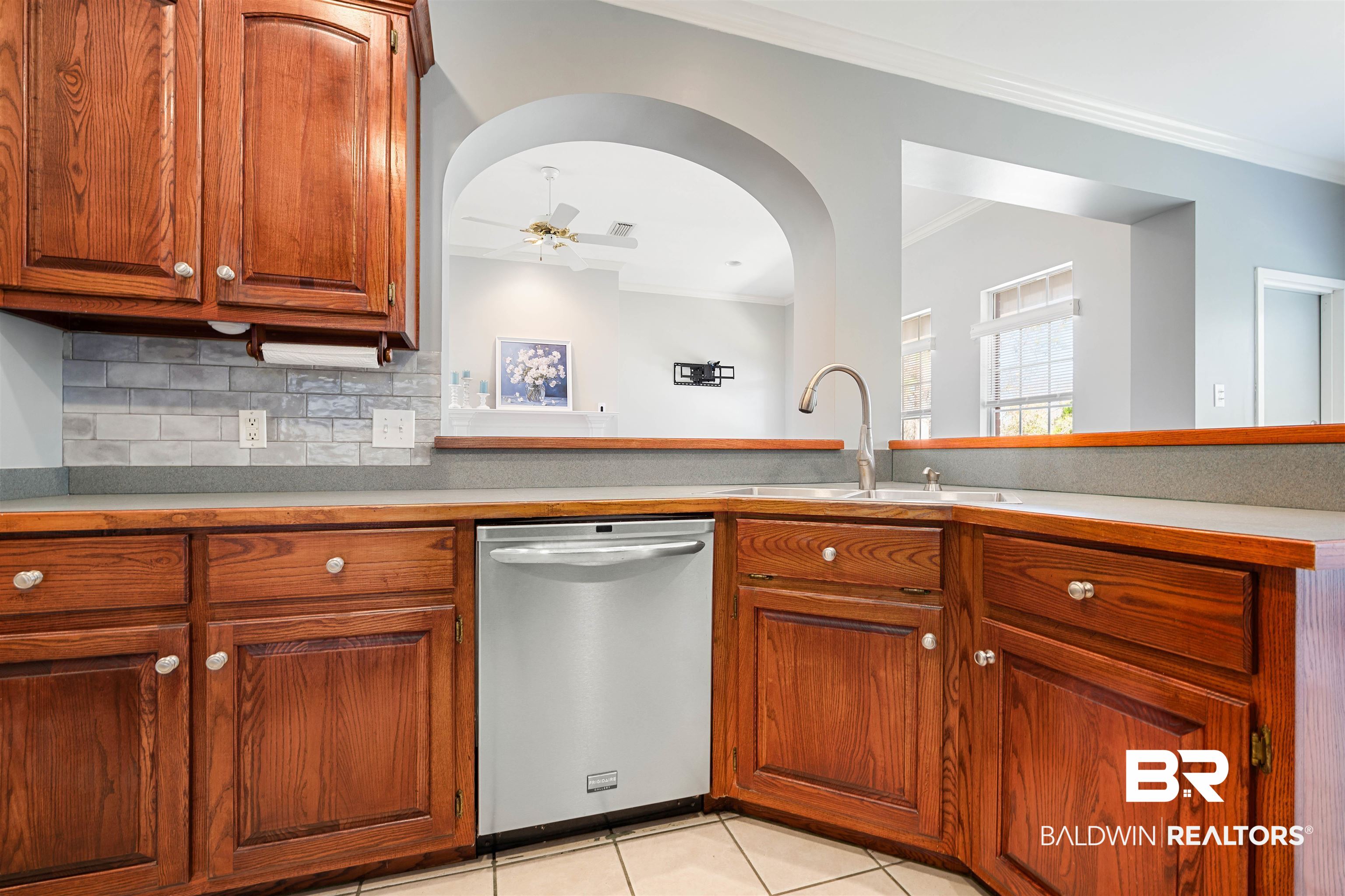 615 Summerlake Place Mobile, AL 36608 - Photo 10 of 35 Kitchen featuring dishwasher, brown cabinets, tasteful backsplash, light tile patterned floors, and a ceiling fan