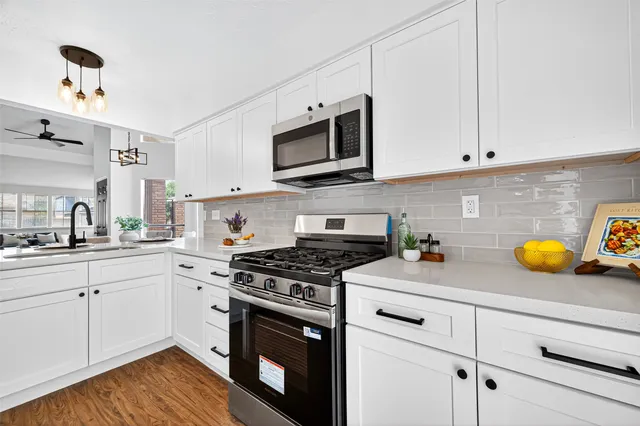 a kitchen with stainless steel appliances a stove a microwave and cabinets