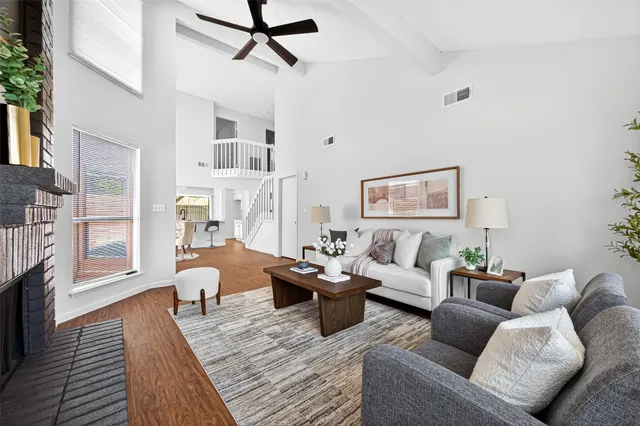 a living room with furniture a fireplace and a chandelier