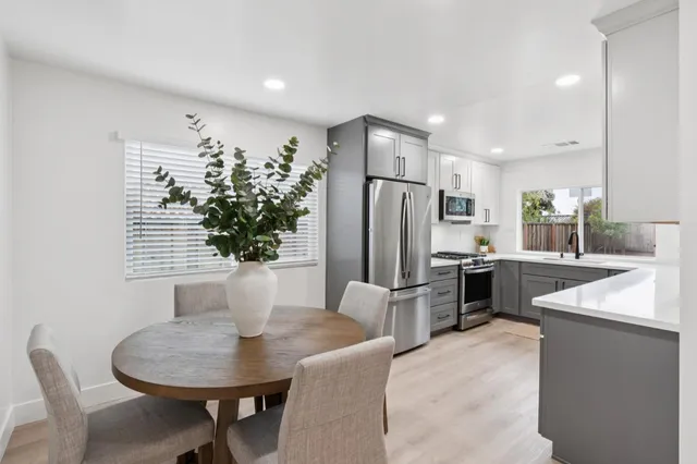 a kitchen with refrigerator and chairs