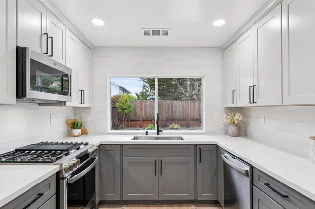 a kitchen with stainless steel appliances a sink stove and cabinets