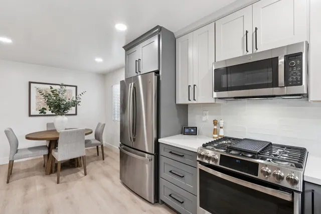 a kitchen with stainless steel appliances a stove microwave and refrigerator