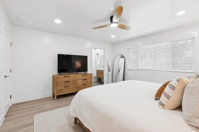 a bedroom with a bed and closet with wooden floor