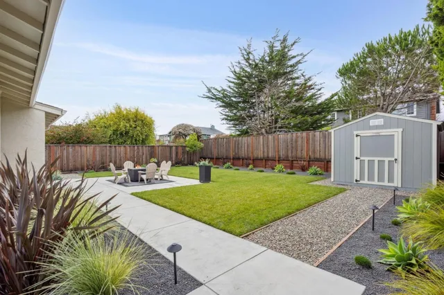 a backyard of a house with table and chairs