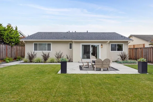 a view of a house with backyard and sitting area