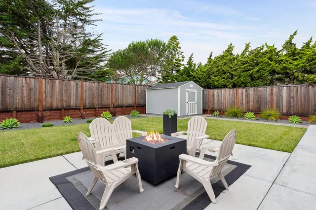 a view of a chair and table in backyard of the house