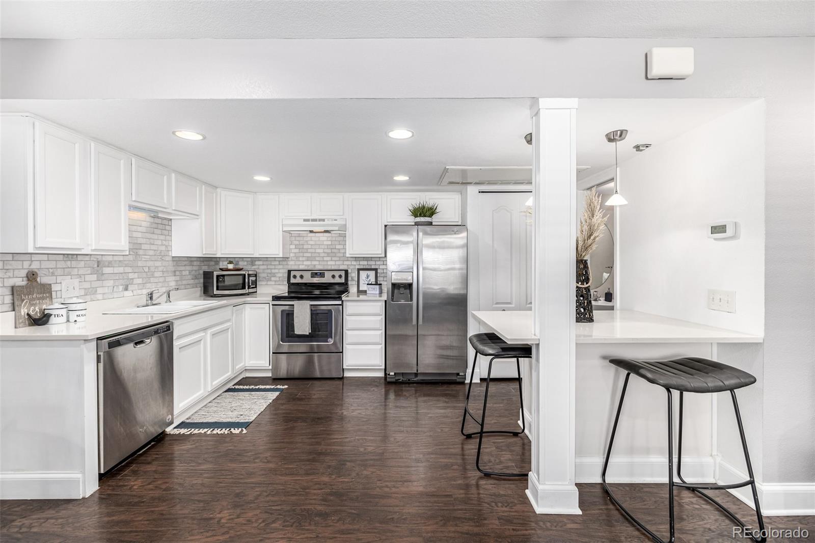 a kitchen with stainless steel appliances kitchen island a refrigerator and a stove top oven