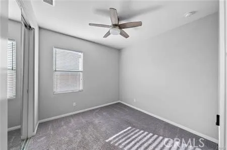 an empty room with a window and a fan