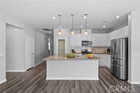 20565 Lost Creek Road Riverside, CA 92507 - Photo 7 of 32 a large kitchen with stainless steel appliances kitchen island granite countertop a refrigerator and a stove top oven