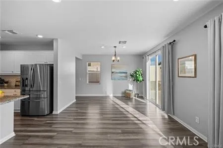 a view of a kitchen with wooden floor and a refrigerator