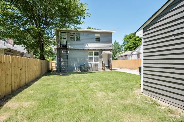 a view of a house with a backyard and a small cabin
