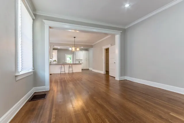 a kitchen with wooden floors and white cabinets