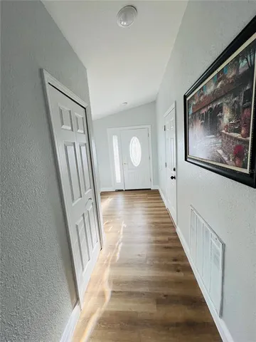 a view of a hallway with wooden floor and staircase