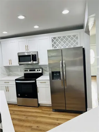 a kitchen with stainless steel appliances granite countertop a refrigerator and a stove