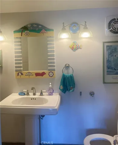 a bathroom with a sink mirror and a toilet
