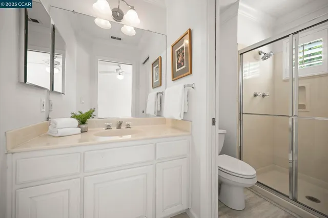 a bathroom with a granite countertop sink a toilet and a mirror