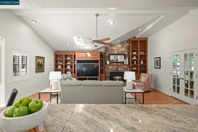a living room with furniture a flat screen tv and a floor to ceiling window