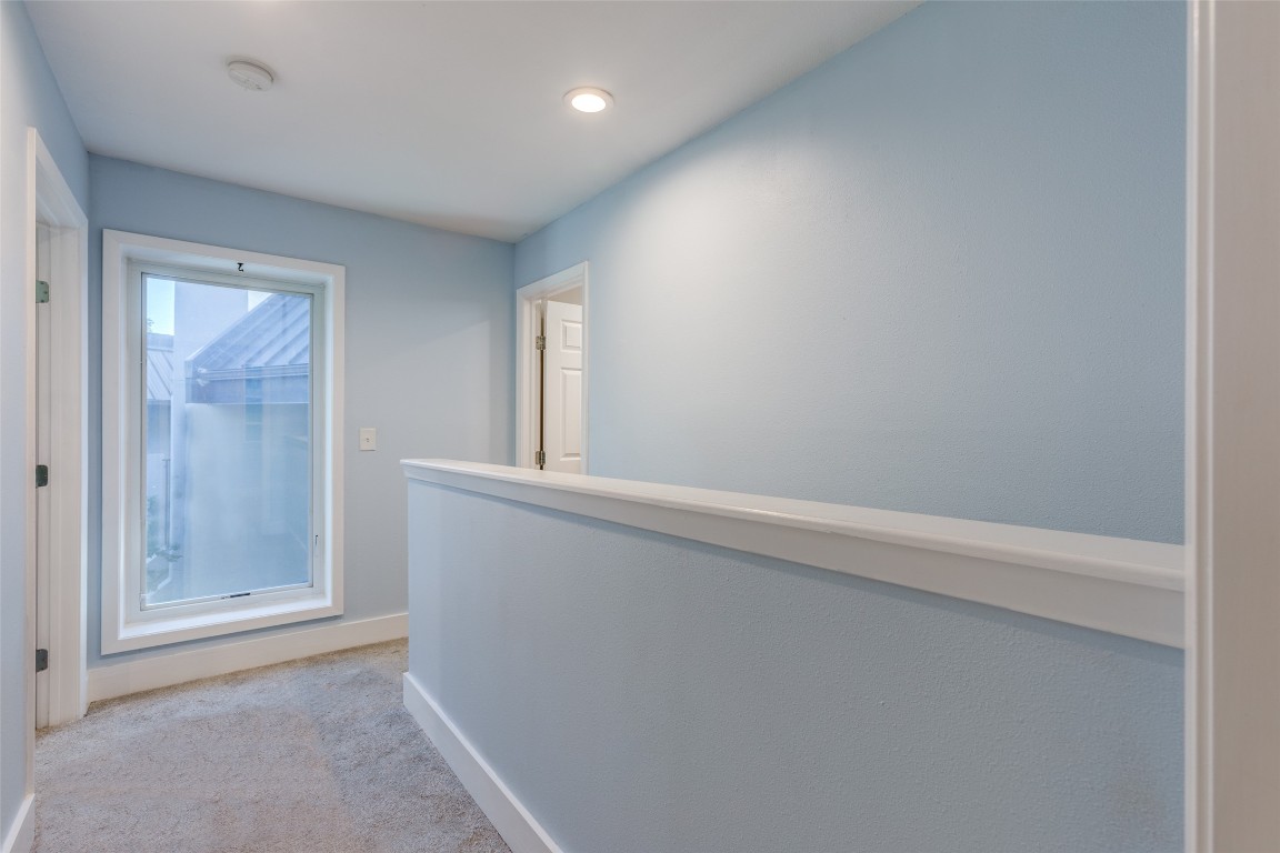 935 La Posada Drive, Unit 155 Austin, TX 78752 - Photo 12 of 25 Hallway with light colored carpet and recessed lighting