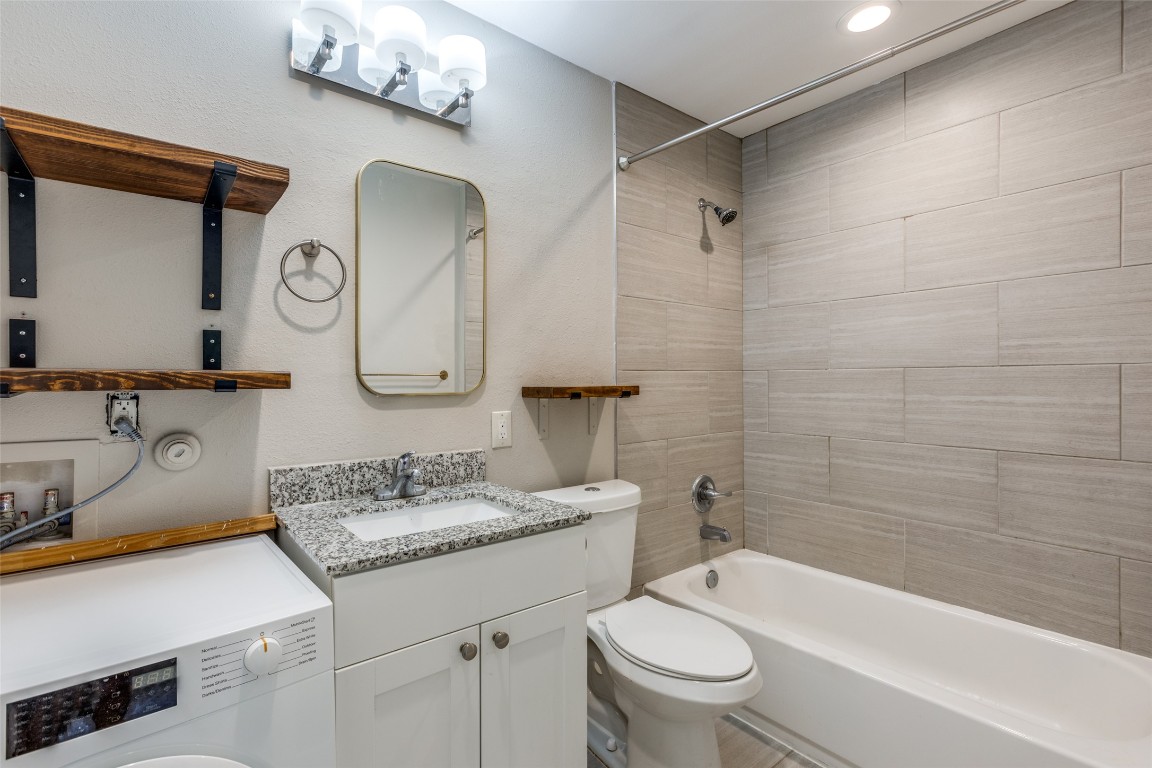 935 La Posada Drive, Unit 155 Austin, TX 78752 - Photo 23 of 25 Full bathroom with washer / dryer, tub / shower combination, vanity, and a textured wall