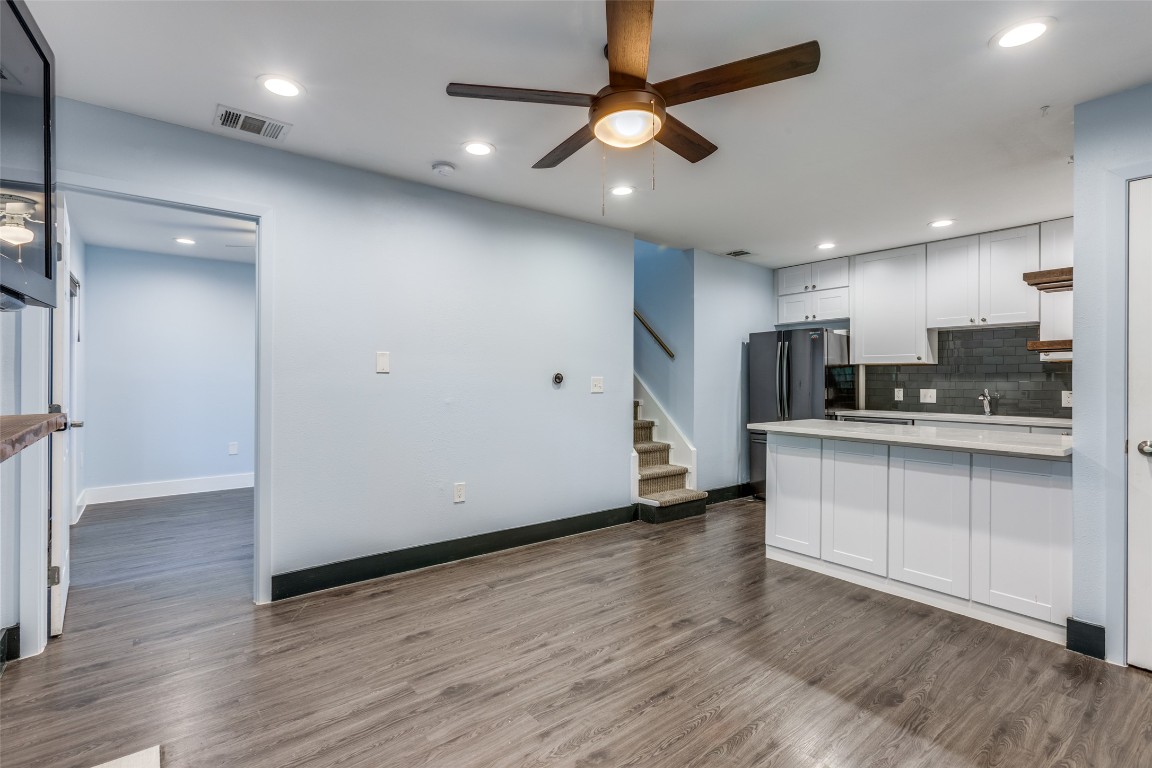 935 La Posada Drive, Unit 155 Austin, TX 78752 - Photo 4 of 25 Kitchen with ceiling fan, tasteful backsplash, dark wood-type flooring, white cabinets, and recessed lighting