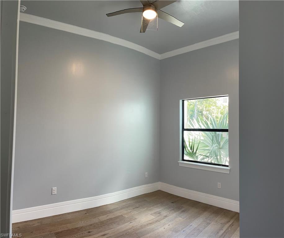 3203 68th Street Southwest Naples, FL 34105 - Photo 23 of 34 an empty room with wooden floor and windows