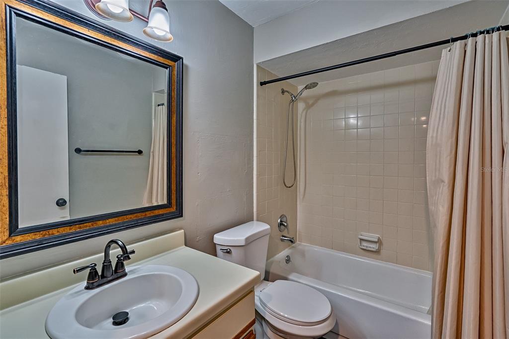 5422 Southwest 4th Place Gainesville, FL 32607 - Photo 17 of 29 a bathroom with a sink a toilet and shower a mirror