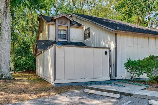 a view of a small house with wooden fence next to a road