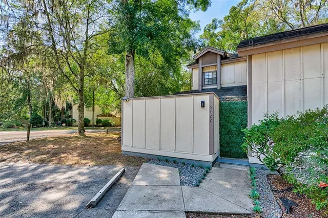 a view of a house with backyard and trees
